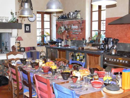 - une cuisine avec une grande table et de la vaisselle dans l'établissement Maison d'hôte la Tourette, à Cucugnan