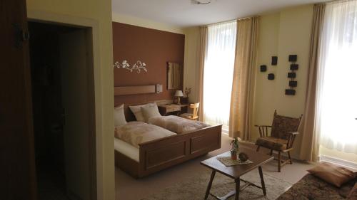 1 dormitorio con 1 cama y 1 silla en una habitación en Gasthof zur Post en Cobbenrode