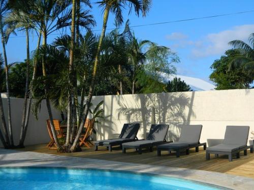 a group of chairs sitting next to a swimming pool at La Rose du Sud in Saint-Joseph