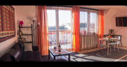 a living room with a couch and a large window at Apartament Serce Miasta | The Heart of the City in Suwałki