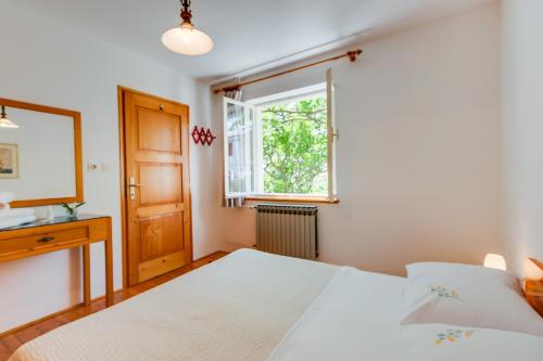sypialnia z łóżkiem i oknem w obiekcie Apartman Pia w miejscowości Mali Lošinj