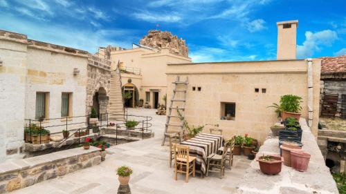 a patio with tables and chairs in front of a building at Maze Of Cappadocia Hotel in Uchisar