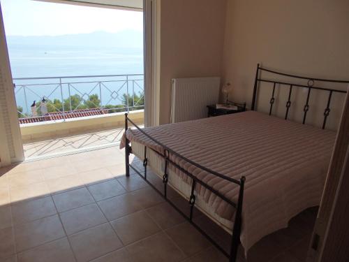 a bedroom with a bed and a view of the ocean at Maria House in Theologos