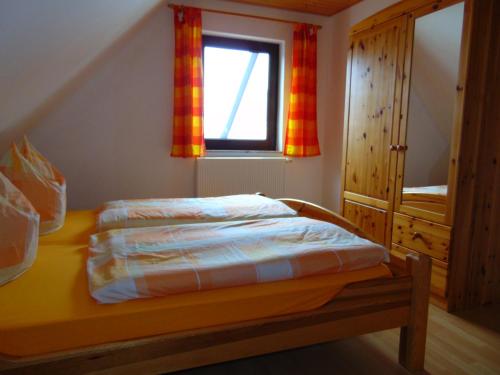 Habitación pequeña con cama y ventana en Ferienhaus Am Peenestrom en Quilitz