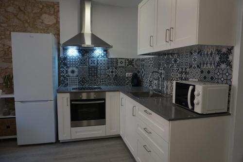 a kitchen with a white refrigerator and a microwave at BOREAS Apartaments in Palamós