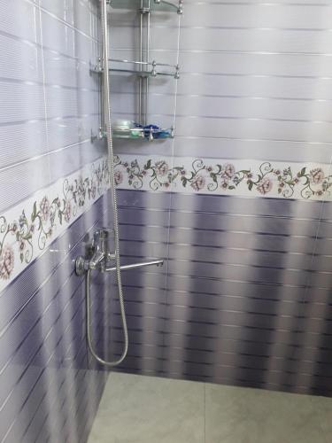 a bathroom with a shower with purple and white tiles at Apartment on Kobuleti beach. in Kobuleti