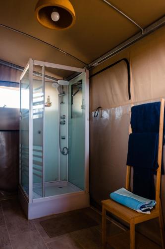 a glass shower in a tent with a chair at Camping Elizabeth in Rethymno