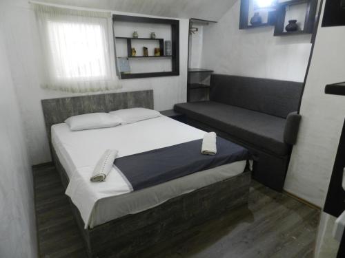 a small bedroom with a bed and a couch at House in Old Batumi in Batumi