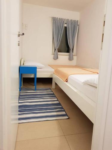 a small bedroom with a bed and a blue table at Apartment Vesna in Podaca