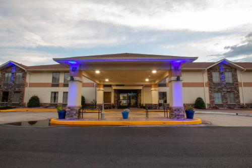 a inn with purple lights on the front of a building at Days Inn & Suites by Wyndham Commerce in Commerce