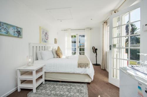 una camera da letto bianca con un letto e una finestra di Emabaleni Guest House PTY LTD a Port Elizabeth