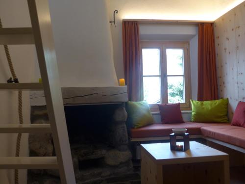a living room with a couch and a fireplace at Ches'Arsa in La Punt-Chamues-ch