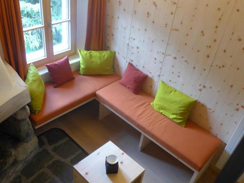 two benches with colorful pillows sitting in a room at Ches'Arsa in La Punt-Chamues-ch