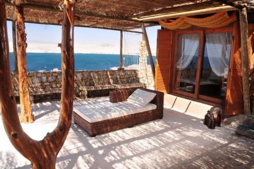 a couch on a porch with a view of the ocean at Hospedaje Boutique Ckamur in Caldera