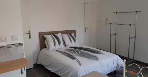 a bedroom with a bed with white sheets and pillows at Val' Appart 1 in Valenciennes