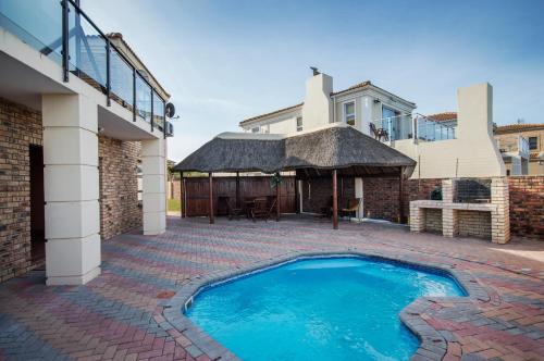 a swimming pool in front of a house at King Guest Lodge in Port Elizabeth