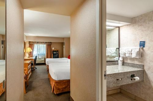 a hotel room with two beds and a bathroom at Red Lion Hotel Rosslyn Iwo Jima in Arlington