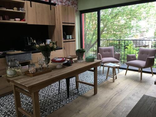 ein Wohnzimmer mit einem Tisch und Stühlen sowie einem Balkon in der Unterkunft B&B PETIT PRINCE, GENT in Gent