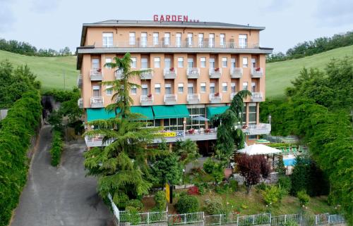 a hotel with a palm tree in front of a building at Albergo Hotel Garden Ristorante in Tabiano