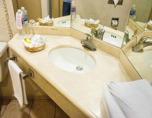 a bathroom with a sink and a mirror at Plaza Inn Express in Tapachula