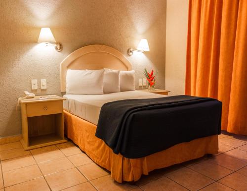 Habitación de hotel con cama y mesa en Plaza Inn Express, en Tapachula