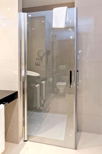 a bathroom with a glass shower with a toilet at Dña Monse Hotel Spa & Golf in Torrevieja