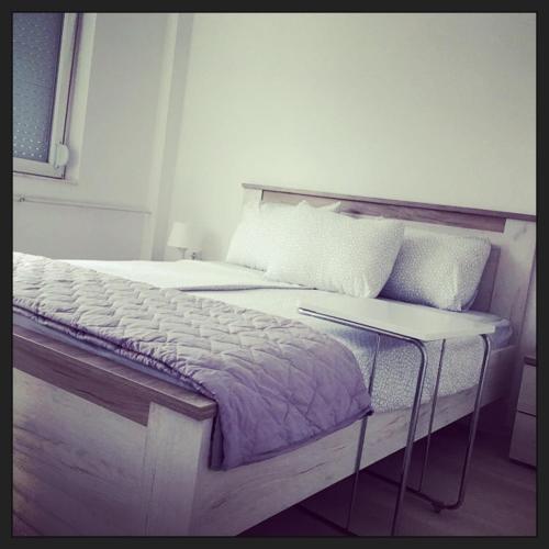 a bedroom with a large bed and a table at 3M Apartment Skopje Center in Skopje