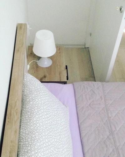 a bedroom with a bed with a lamp on the floor at 3M Apartment Skopje Center in Skopje