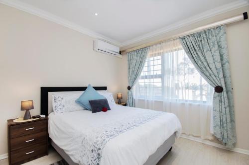 a bedroom with a bed and a large window at King Guest Lodge in Port Elizabeth