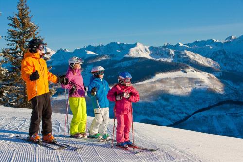 a group of people standing on top of a ski slope at Tivoli Lodge in Vail