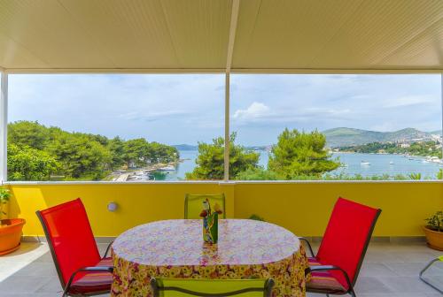 a table and chairs in a room with a large window at Apartment Baturina in Trogir