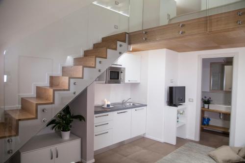 a kitchen with white cabinets and a staircase at Le Dimore Di Puglia - Palazzo Pinto in Monopoli