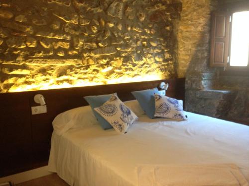 een slaapkamer met een bed met een schilderij aan de muur bij Cal Matiner Casa Rural *** in Salsadella