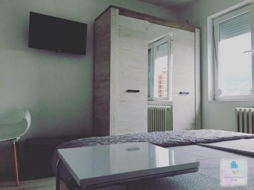a bedroom with a bed with a tv on the wall at 3M Apartment Skopje Center in Skopje