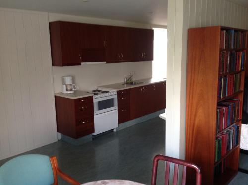 a kitchen with brown cabinets and a white stove top oven at Fraendgardur in Hofsós