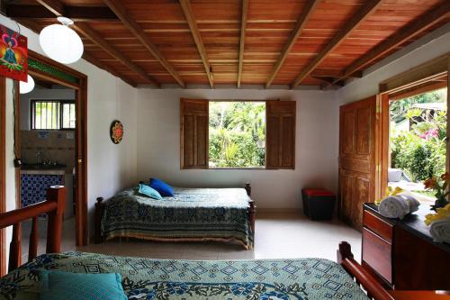 1 dormitorio con 1 cama y 2 ventanas en Claro de Luna, en Salento