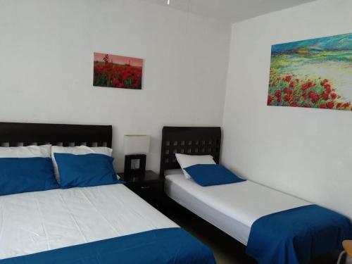 two beds sitting next to each other in a room at Posada San Cristobal in Cuernavaca