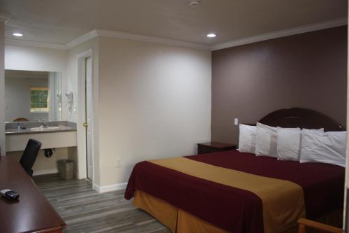 a hotel room with a bed and a bathroom at Value Inn & Suites in Redding