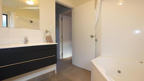 a bathroom with a black and white sink and a tub at Bk's Counties Motor Lodge in Pukekohe East