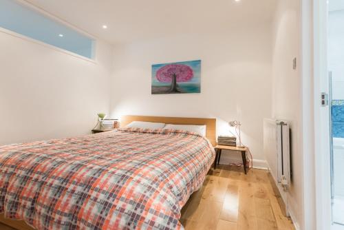 a bedroom with a bed with a plaid blanket at Central Home with Parking near Waterloo & St Thomas & Big Ben & Parliament in London