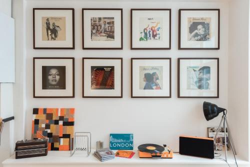 a row of framed pictures on a white wall at Central Home with Parking near Waterloo & St Thomas & Big Ben & Parliament in London