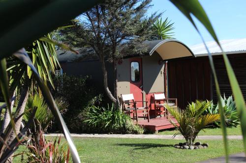 a house with a deck and chairs on it at Solscape in Raglan