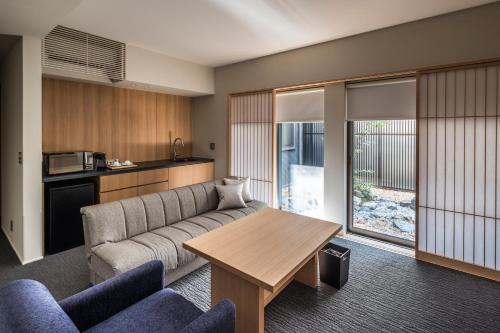 a living room with a couch and a table at Tomoya Residence Hotel Kyoto in Kyoto