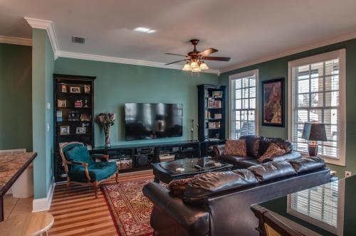 a living room with a leather couch and a tv at Rick's Downtown Nashville Guest House in Nashville
