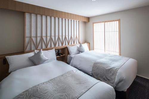 Säng eller sängar i ett rum på Tomoya Residence Hotel Kyoto