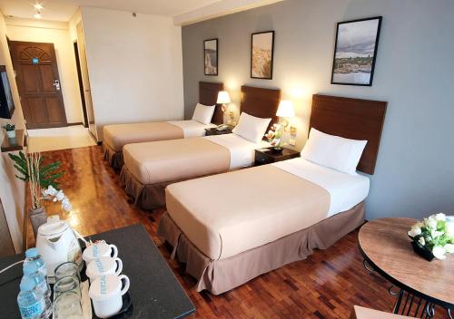 a hotel room with two beds and a table at Fersal Hotel Kalayaan, Quezon City in Manila