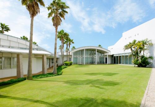 an exterior view of a building with palm trees at Hotel Emion Tokyo Bay in Urayasu
