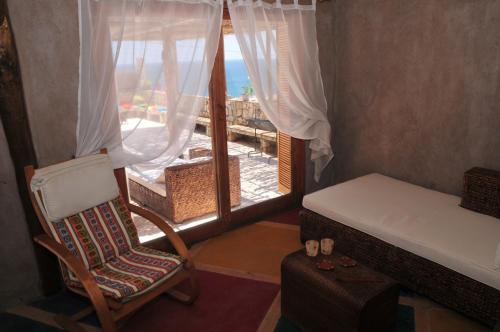 een kamer met een stoel en een raam met uitzicht bij Hospedaje Boutique Ckamur in Caldera