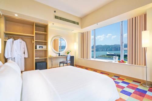 ein Schlafzimmer mit einem großen Bett und einem großen Fenster in der Unterkunft Hotel COZi Harbour View in Hongkong