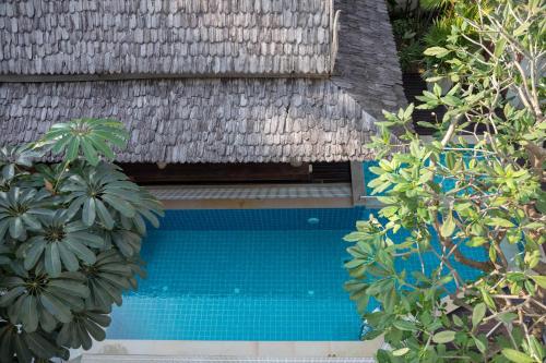 a swimming pool next to a building with plants at Charlie House Pin Klao in Bangkok